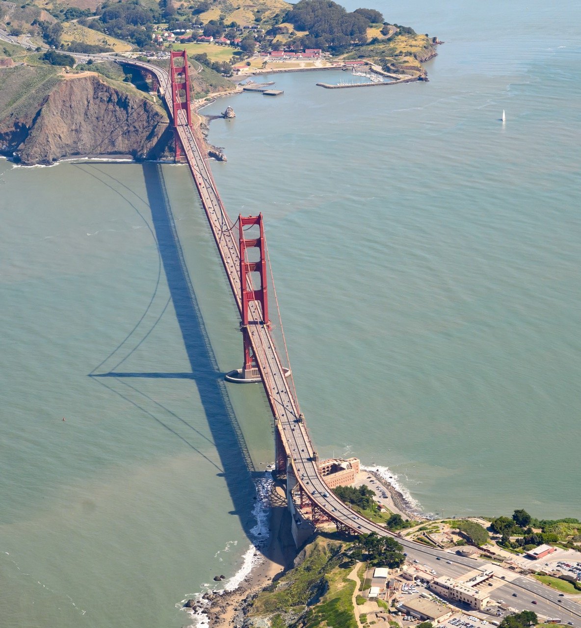 Aerial photograph of the Golden Gate Bridge spanning the Golden Gate strait, looking south toward San Francisco. Photo by Josh Edelson.