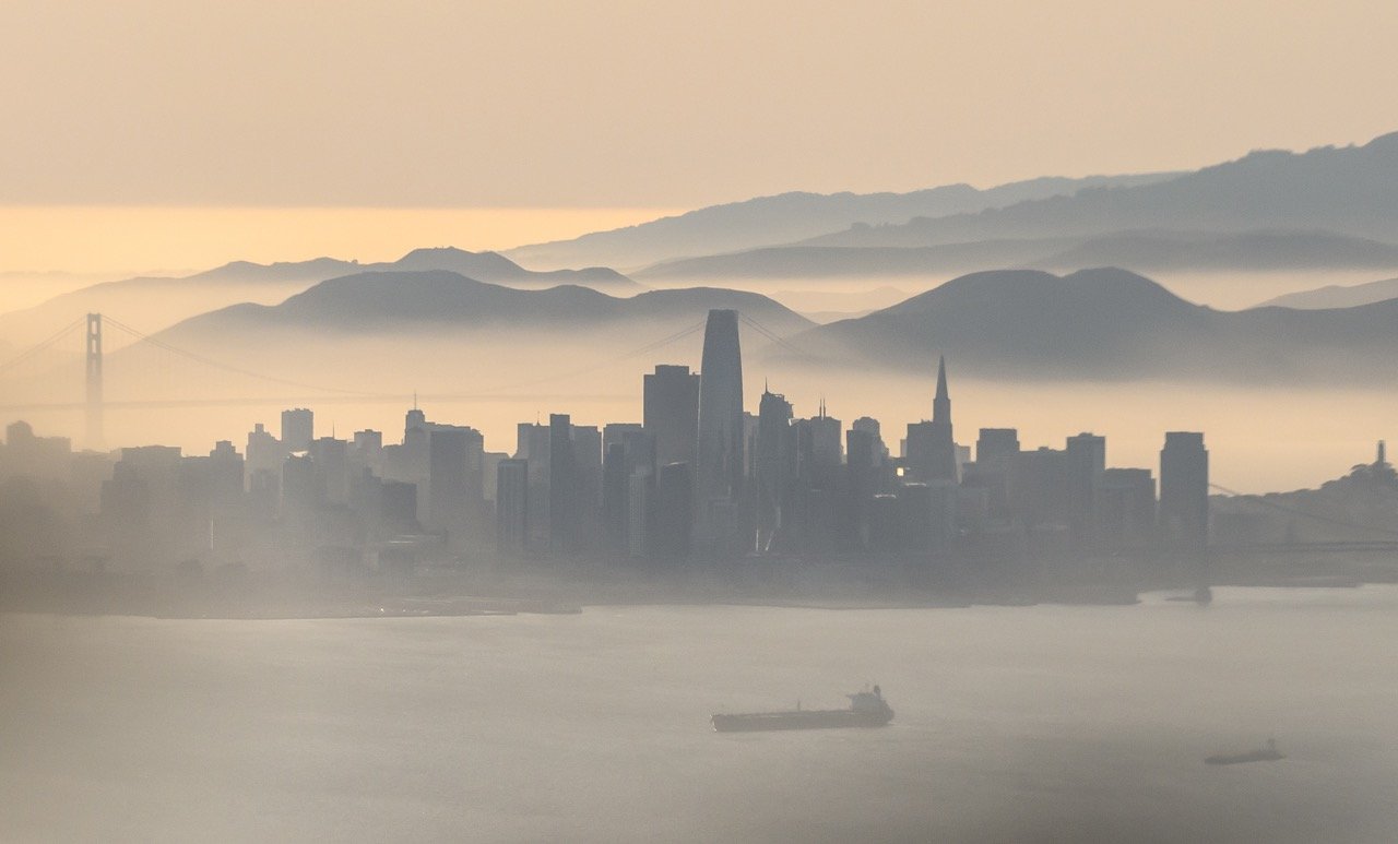The San Francisco Bay Area from above, with marine fog rolling in toward the downtown San Francisco skyline. Photo by Josh Edelson.