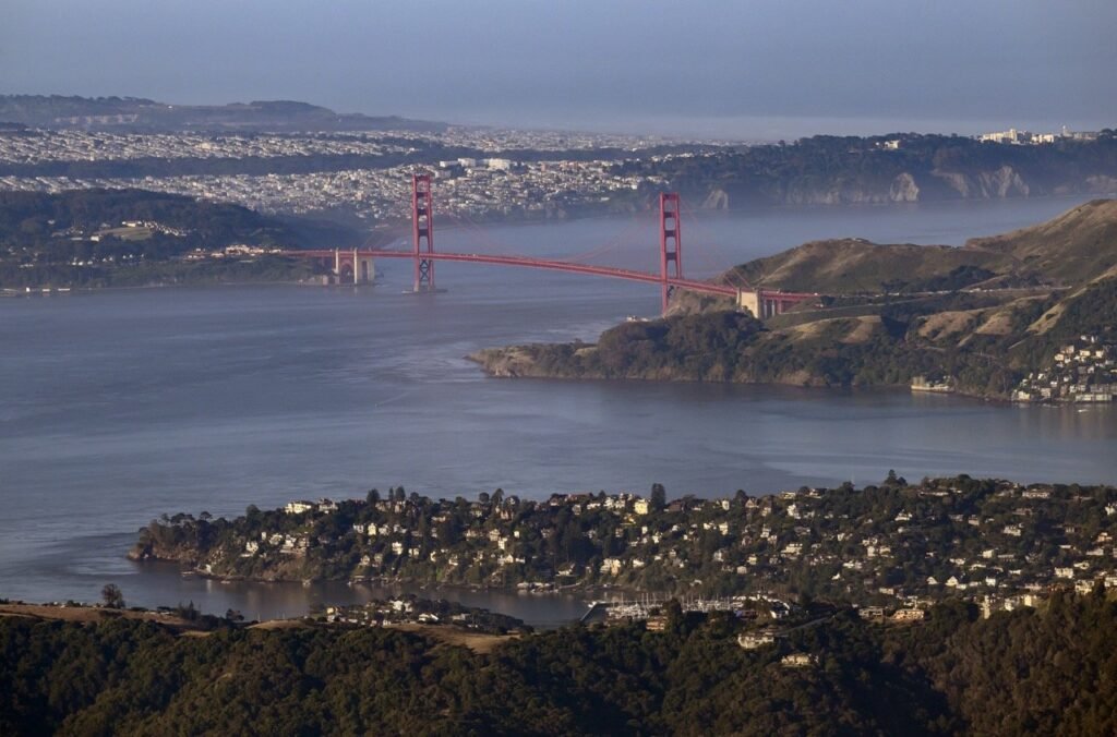 Wide aerial view of the Golden Gate Bridge spanning the entrance to the San Francisco Bay — fixed-wing aerial photography by Josh Edelson