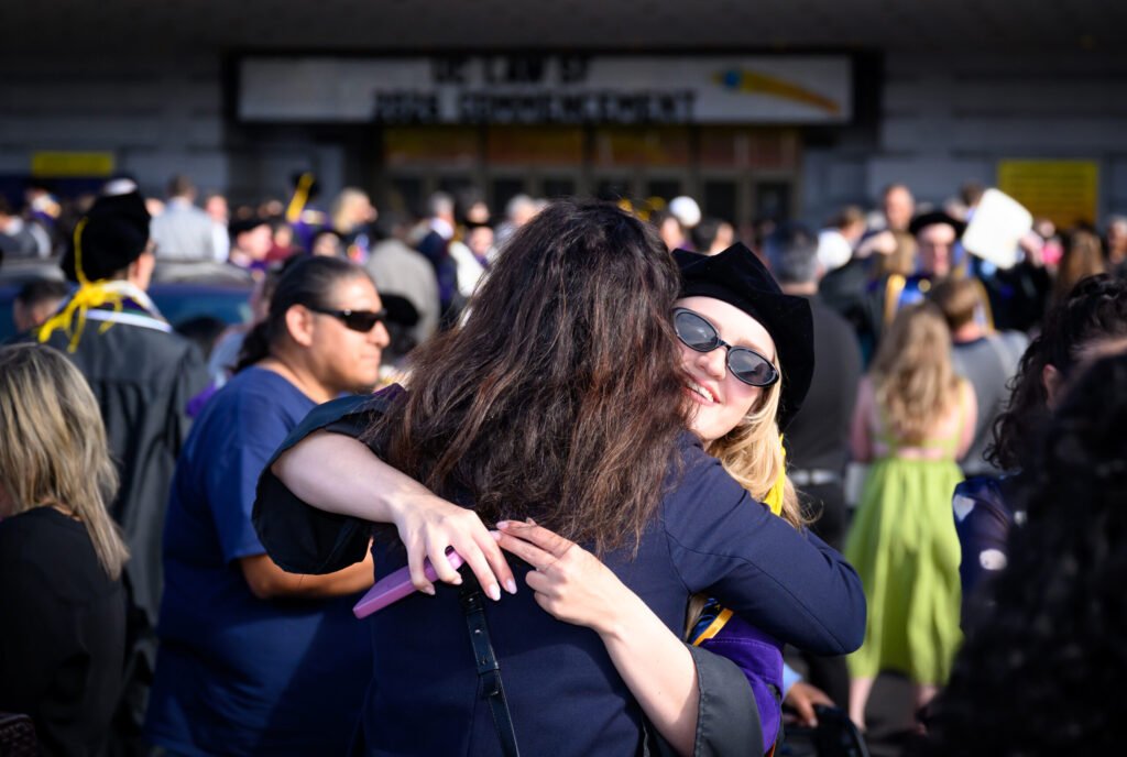 UC Law San Francisco graduate displays school hood outside after 2026 commencement ceremony — photo by Josh Edelson