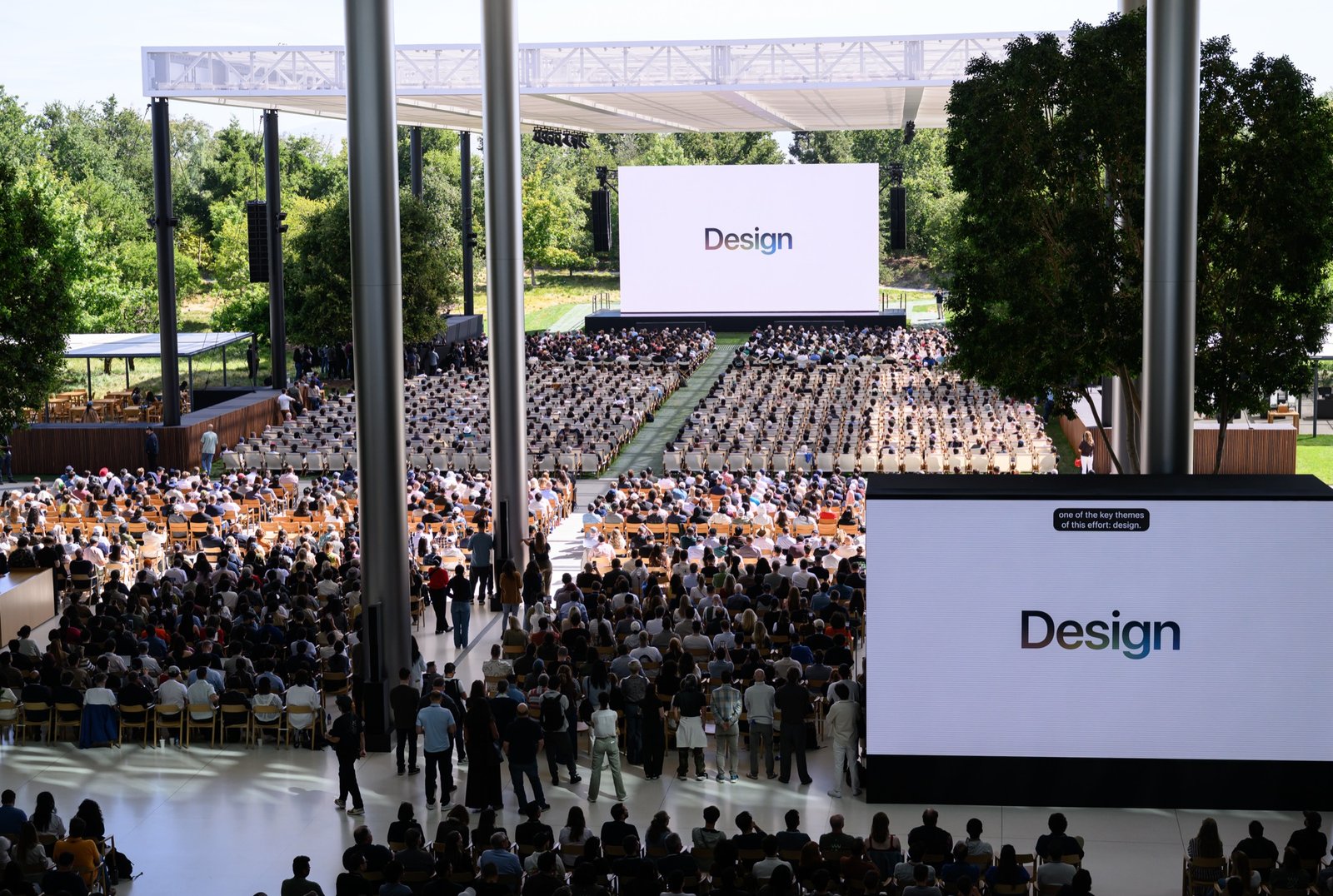 Audience seated in the Apple Park amphitheater during the WWDC 2026 keynote, with "Design" shown on the large stage screens