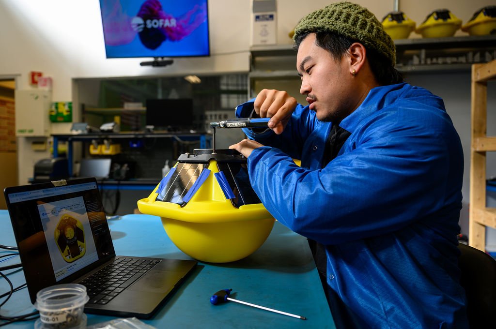 Office and lifestyle photography by Josh Edelson — engineer at the assembly bench in a San Francisco workshop.