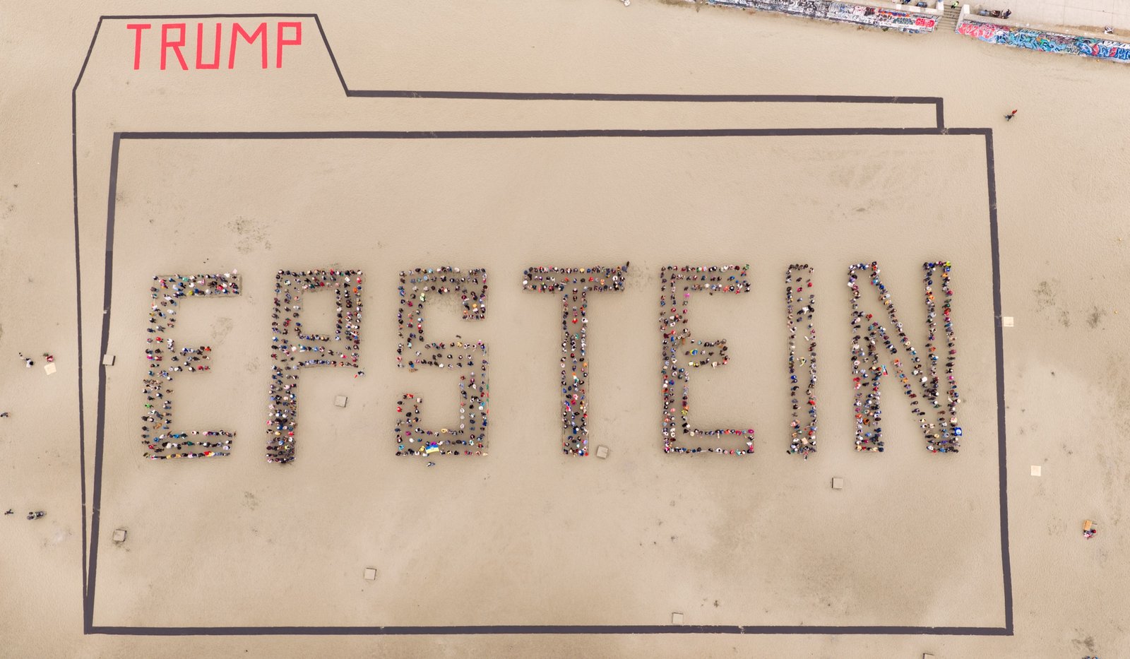 Top-down aerial drone view of a human banner shaped like a file folder labeled TRUMP and containing the word EPSTEIN at Ocean Beach, San Francisco