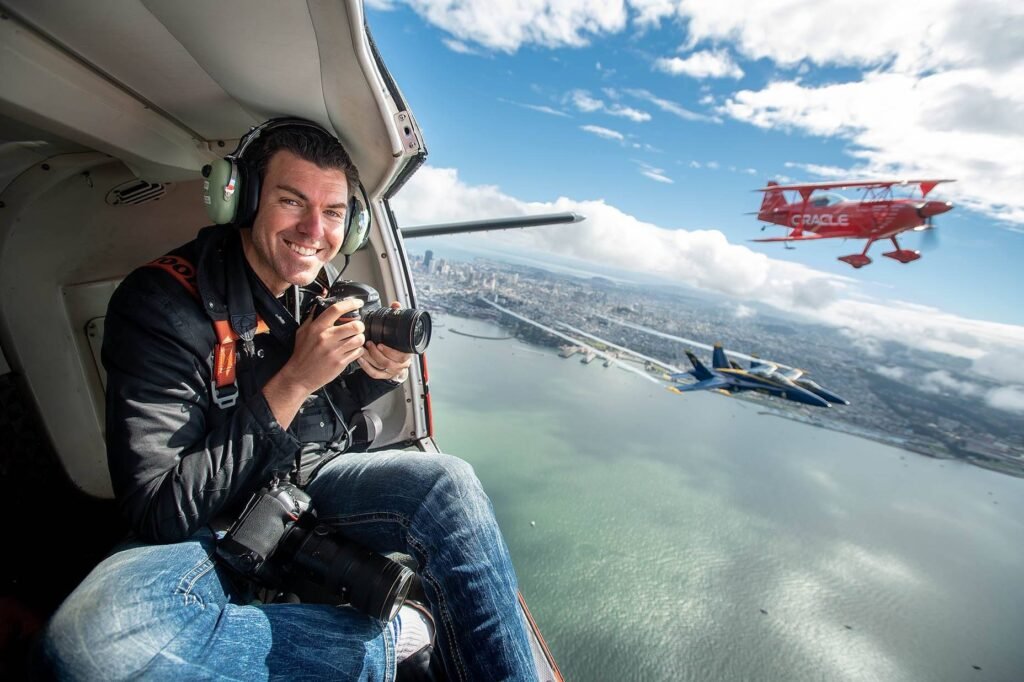 Josh Edelson photographing an air show from a helicopter over San Francisco