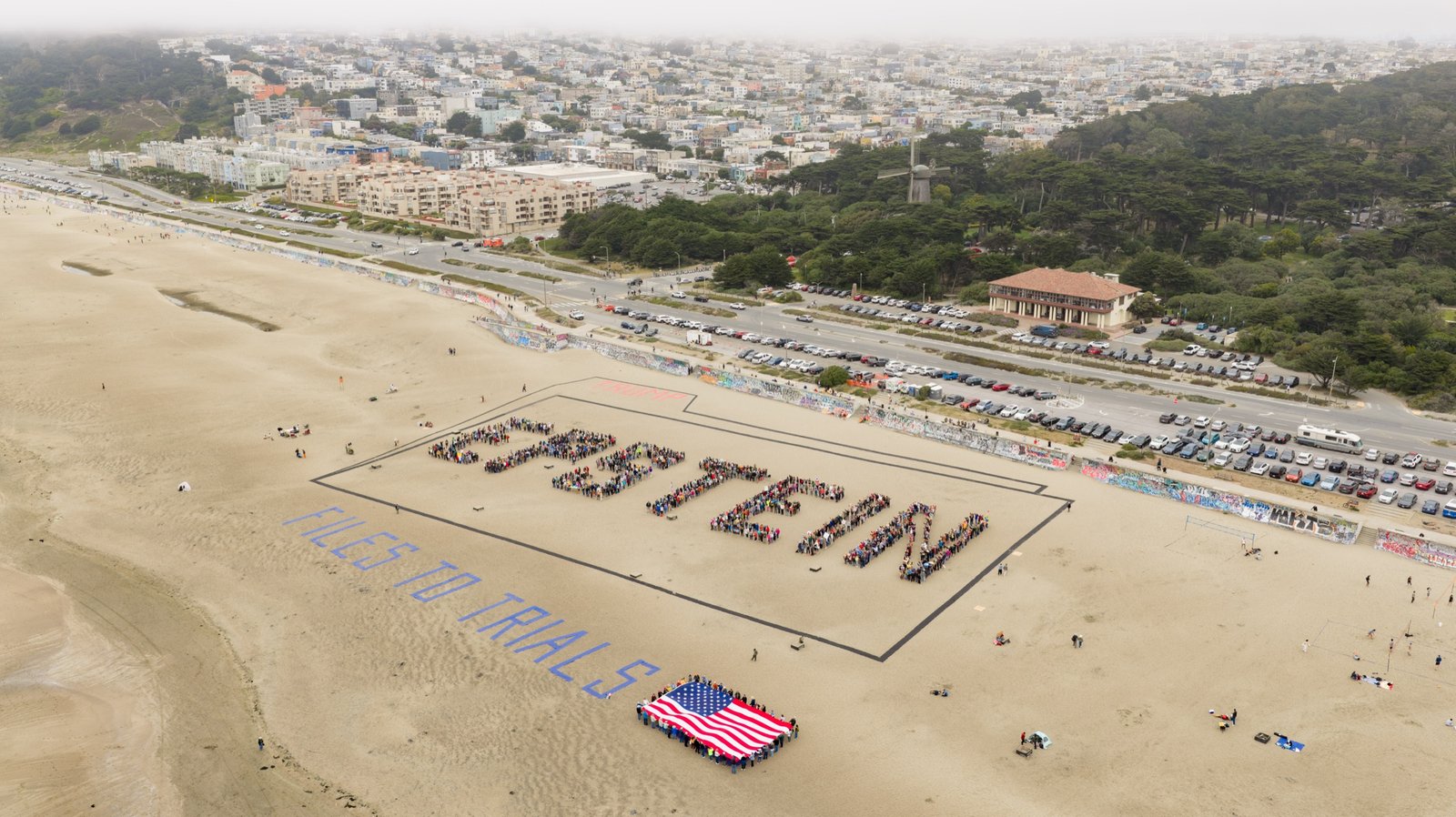 More than 1,000 demonstrators spell out EPSTEIN on Ocean Beach in San Francisco. Aerial photo by Josh Edelson, on assignment for the San Francisco Chronicle.