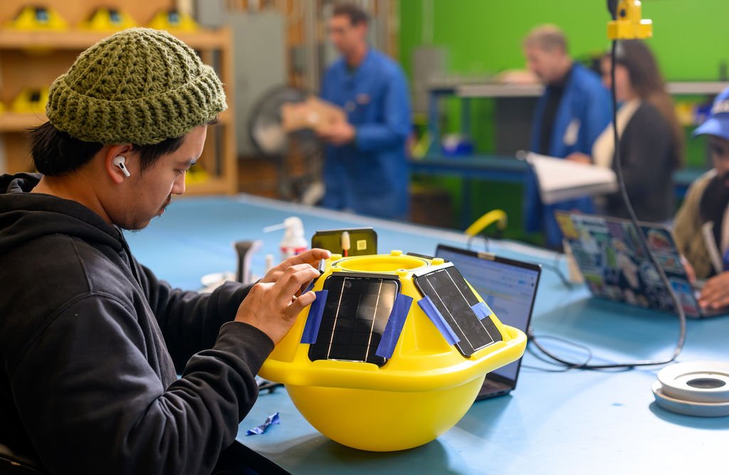 A Sofar Ocean Technologies engineer working on a Spotter Buoy in the San Francisco workshop