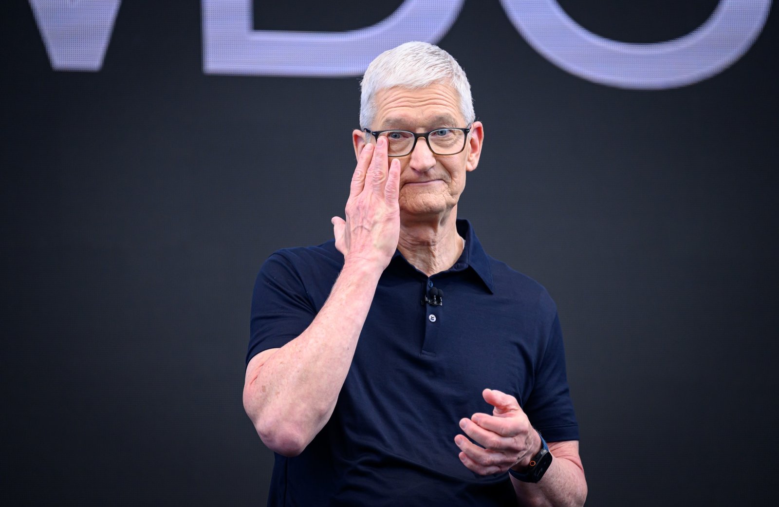 Apple CEO Tim Cook wiping a tear from his eye, looking emotional, on stage at his final WWDC keynote in 2026