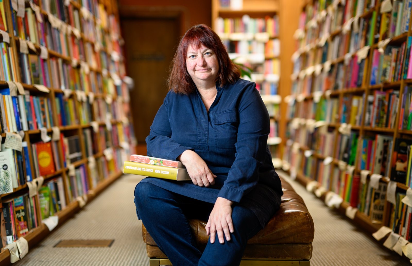 Environmental portrait of Booksmith owner Christin Evans among the shelves of her San Francisco bookstore, by Josh Edelson
