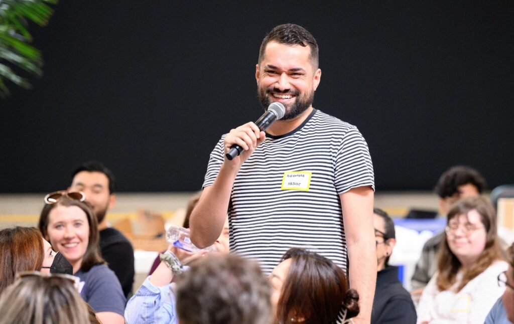 An attendee asking a question at the microphone during a corporate event Q and A, event photography by Josh Edelson