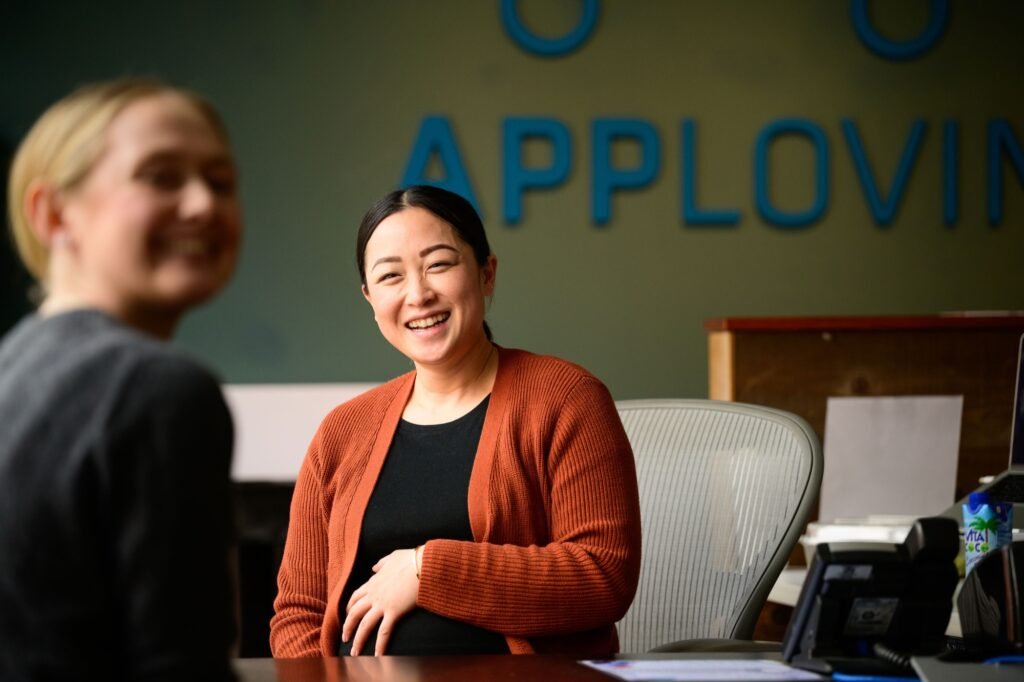 A smiling employee at her desk in a San Francisco technology office, corporate office and lifestyle photography by Josh Edelson