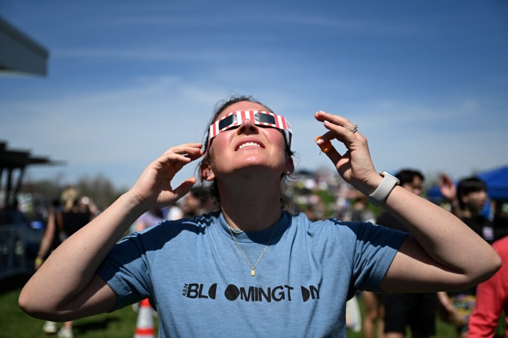 A woman watches the 2024 total solar eclipse in Bloomington, Indiana, photographed by Josh Edelson