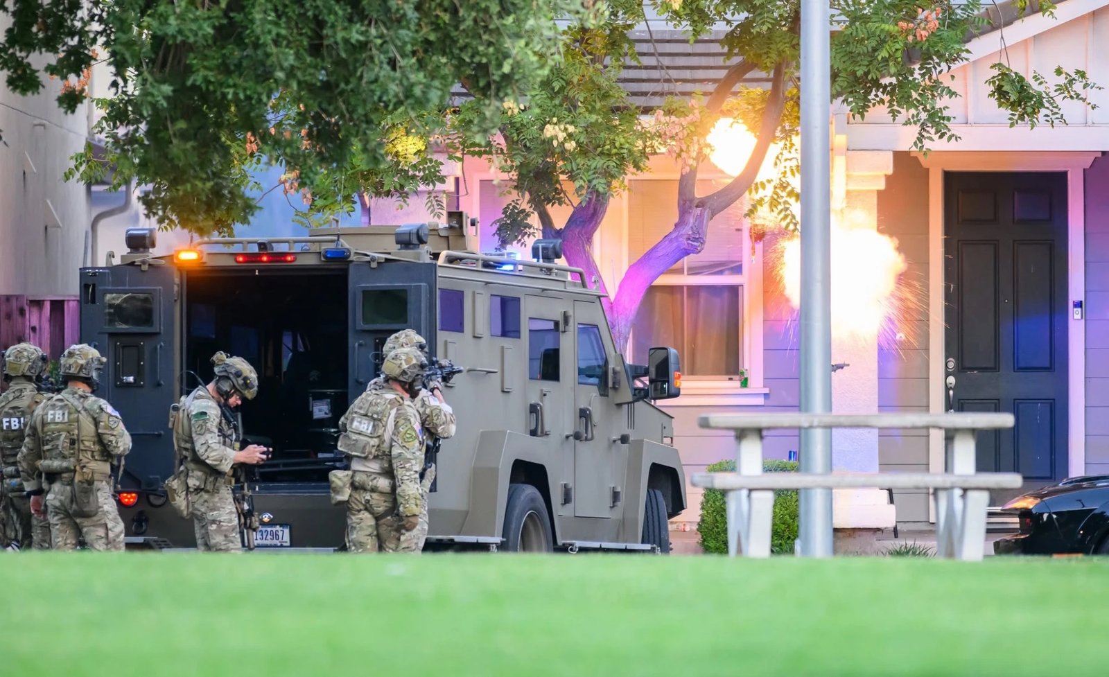 A flash-bang detonates as the SWAT team moves in.