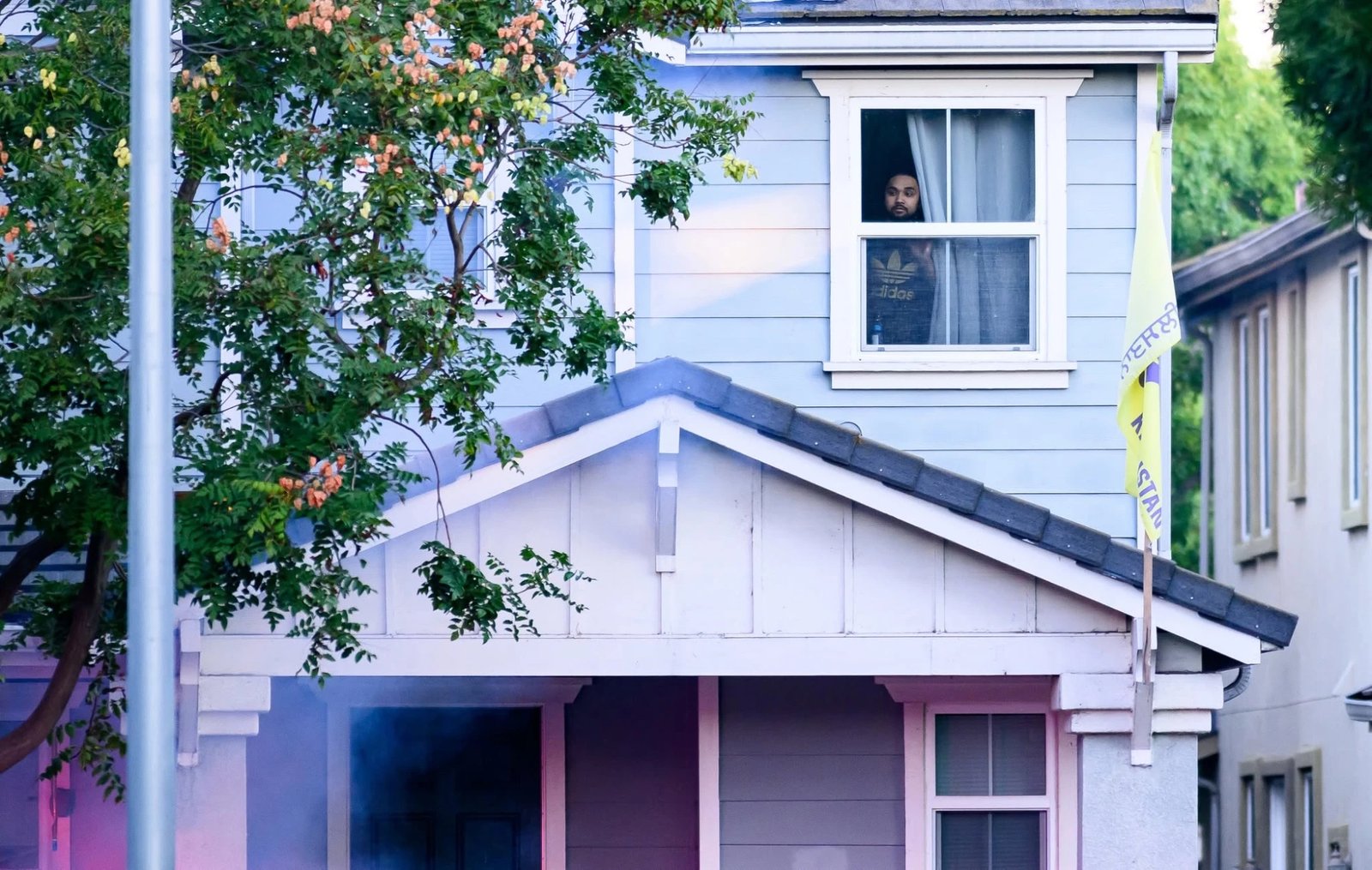 A man watches from an upstairs window as the operation begins.