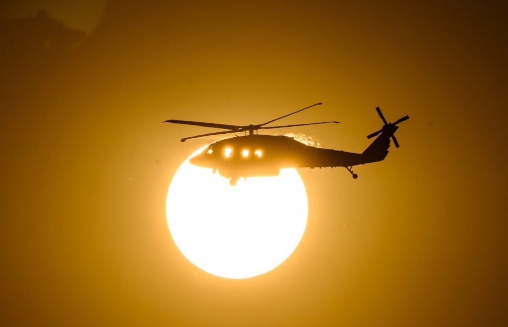 A firefighting helicopter crosses in front of the sun at the Little Fire in Pleasanton, California, photographed on assignment for AFP by Josh Edelson