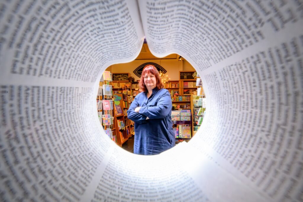 Booksmith owner Christin Evans photographed through the pages of a magazine at her San Francisco bookstore for the LA Times, by Josh Edelson