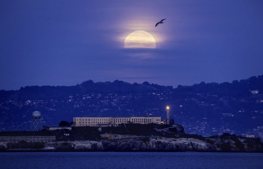 The moon rising over Alcatraz and San Francisco Bay at dusk, by Josh Edelson