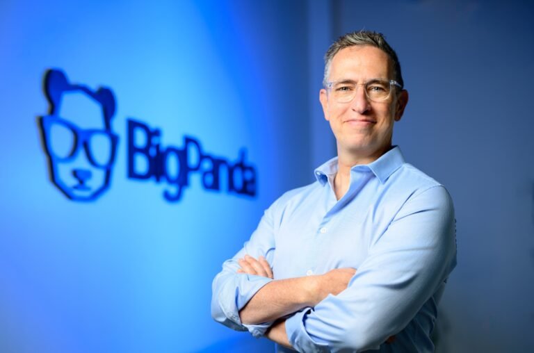 BigPanda CEO executive portrait lit against the company logo in blue, photographed by Josh Edelson in Redwood City, California