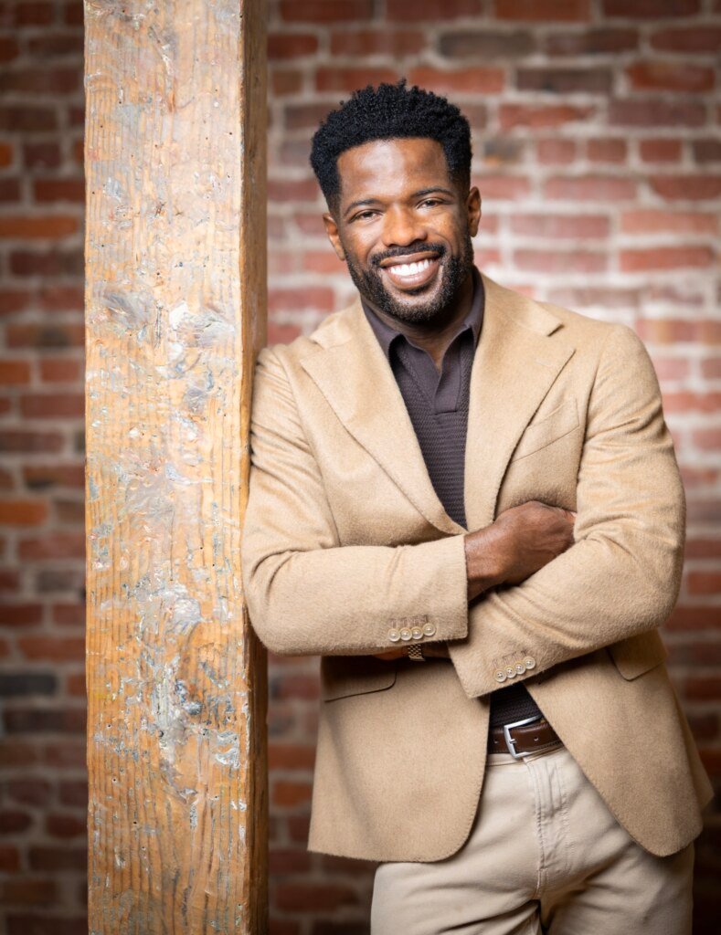 Kevin Caldwell, CEO of Ossium Health, executive portrait in a camel blazer against brick, photographed in San Francisco by Josh Edelson