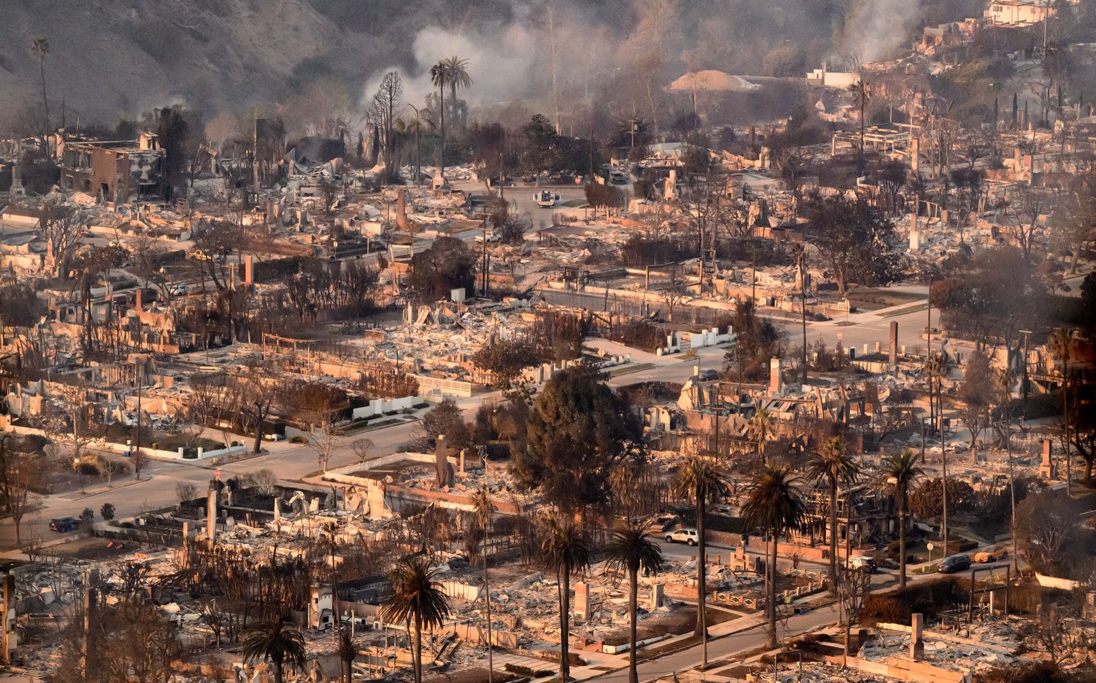 In this aerial view taken from a helicopter, homes burned from the Palisade fire smolder near the Pacific Palisades area of Los Angeles county, California on January 09, 2025. (Josh Edelson / AFP)
