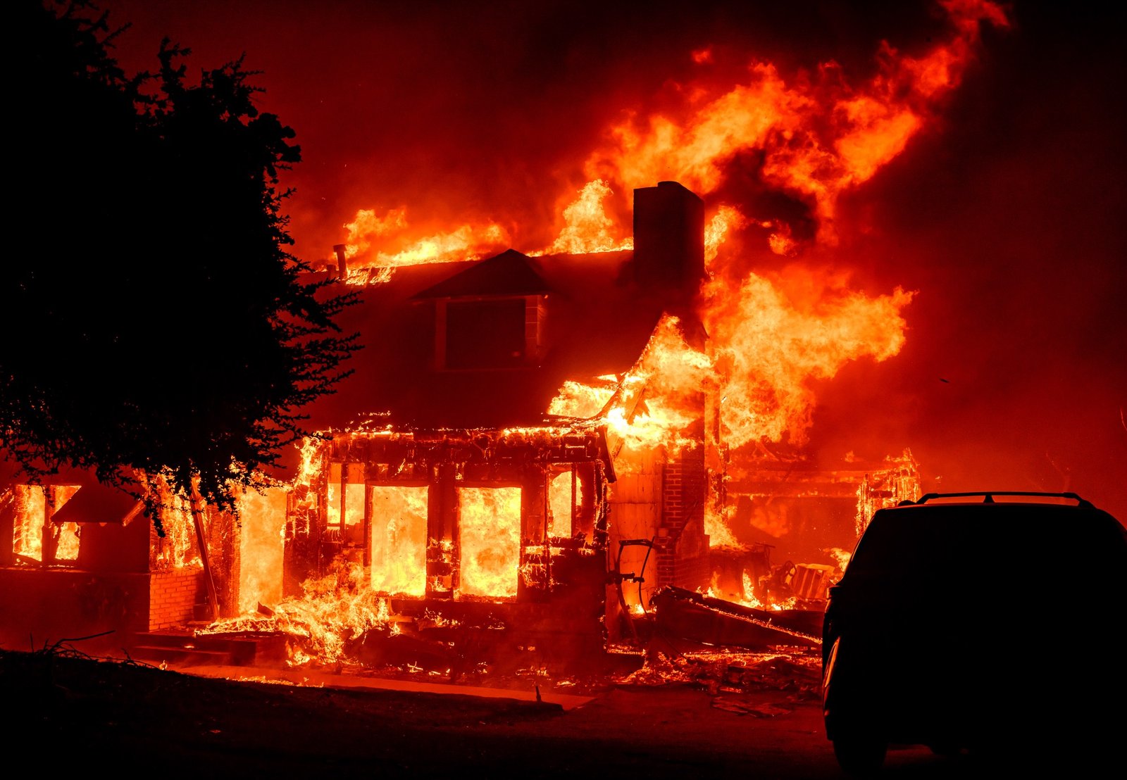 A home burns during the Eaton fire in the Altadena area of Los Angeles County, California on January 08, 2025. Multiple fast-moving wildfires broke out in Los Angeles county burning buildings and causing thousands to evacuate as "life threatening" winds whipped the region. Frightened residents abandoned their cars on one of the only roads in and out of the upscale Pacific Palisades area, fleeing on foot from the 770-acre (310-hectare) blaze engulfing an area crammed with multi-million dollar homes in the Santa Monica Mountains. (Josh Edelson / AFP)