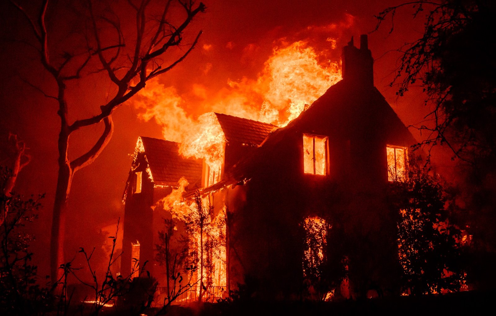 A home burns during the Eaton fire in the Altadena area of Los Angeles County, California on January 08, 2025. Multiple fast-moving wildfires broke out in Los Angeles county burning buildings and causing thousands to evacuate as "life threatening" winds whipped the region. Frightened residents abandoned their cars on one of the only roads in and out of the upscale Pacific Palisades area, fleeing on foot from the 770-acre (310-hectare) blaze engulfing an area crammed with multi-million dollar homes in the Santa Monica Mountains. (Josh Edelson / AFP)