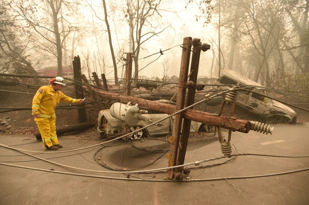 Retired CalFire firefighter Scott Wit surveys abandoned burned vehicles on the side of the road after the Camp fire tore through the area in Paradise, California on November 10, 2018. (Josh Edelson / AFP)