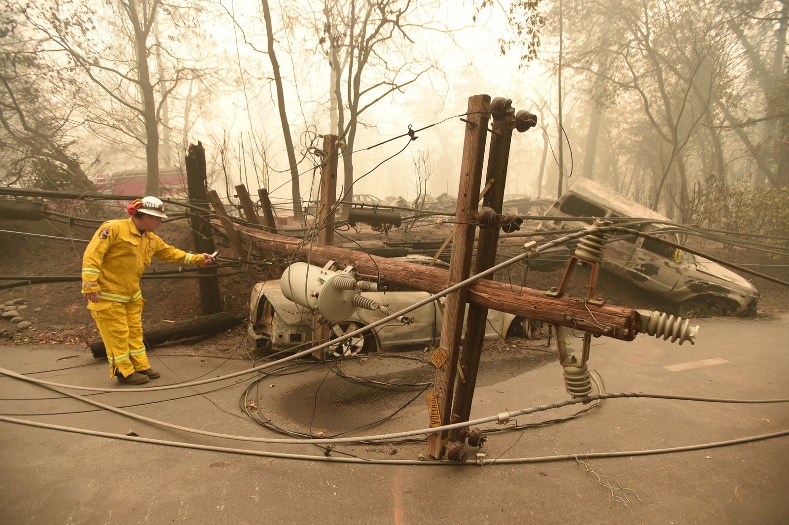 Retired CalFire firefighter Scott Wit surveys abandoned burned vehicles on the side of the road after the Camp fire tore through the area in Paradise, California on November 10, 2018. (Josh Edelson / AFP)